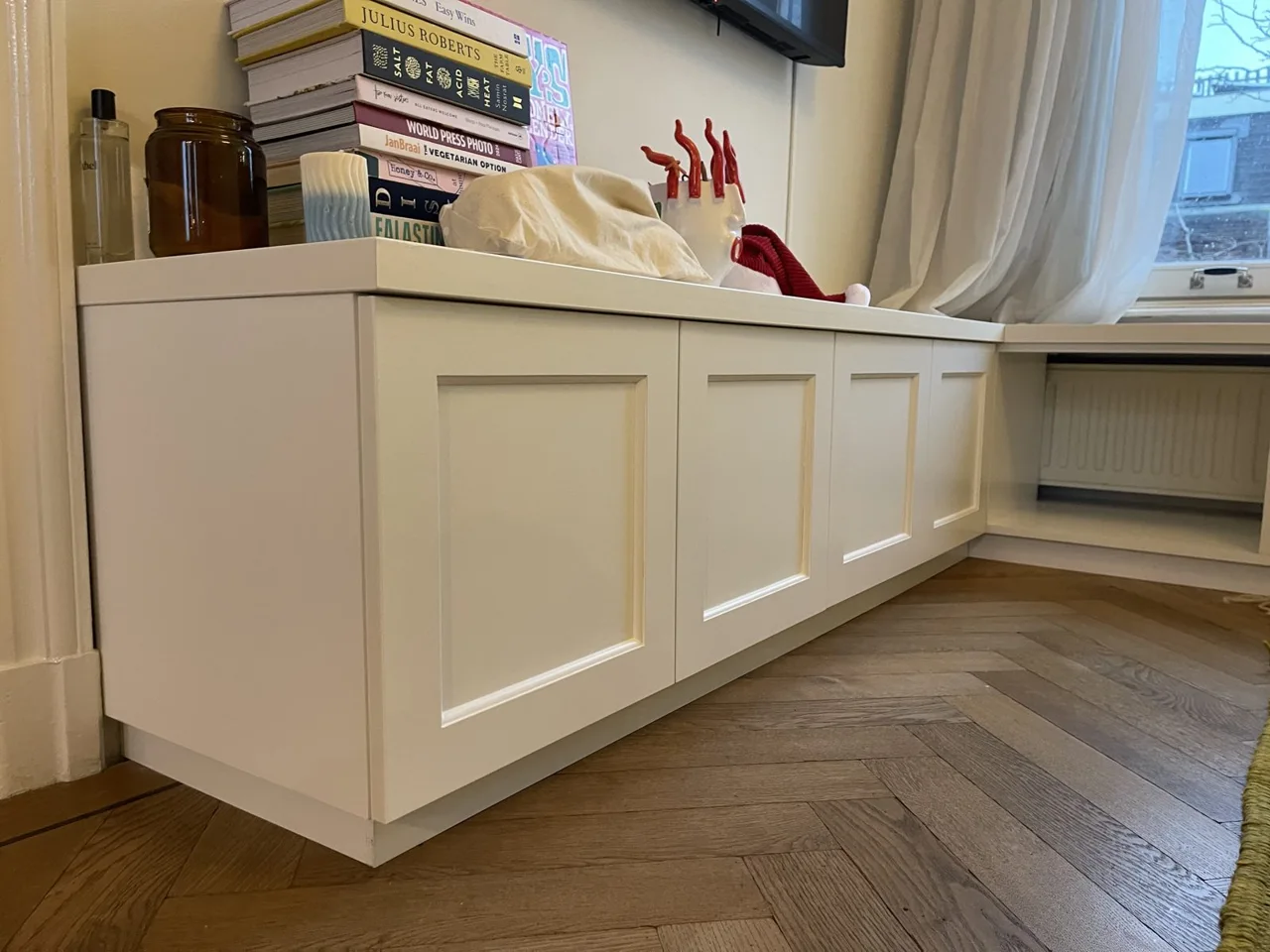 Kastenwand met zitbank onder het raam