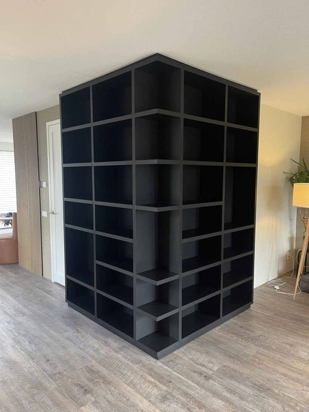 Zwarte vakkenkast als roomdivider
