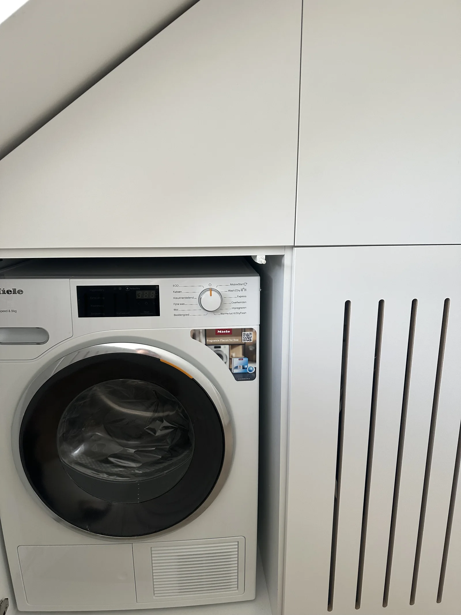 De wasmachine achter de kastdeur